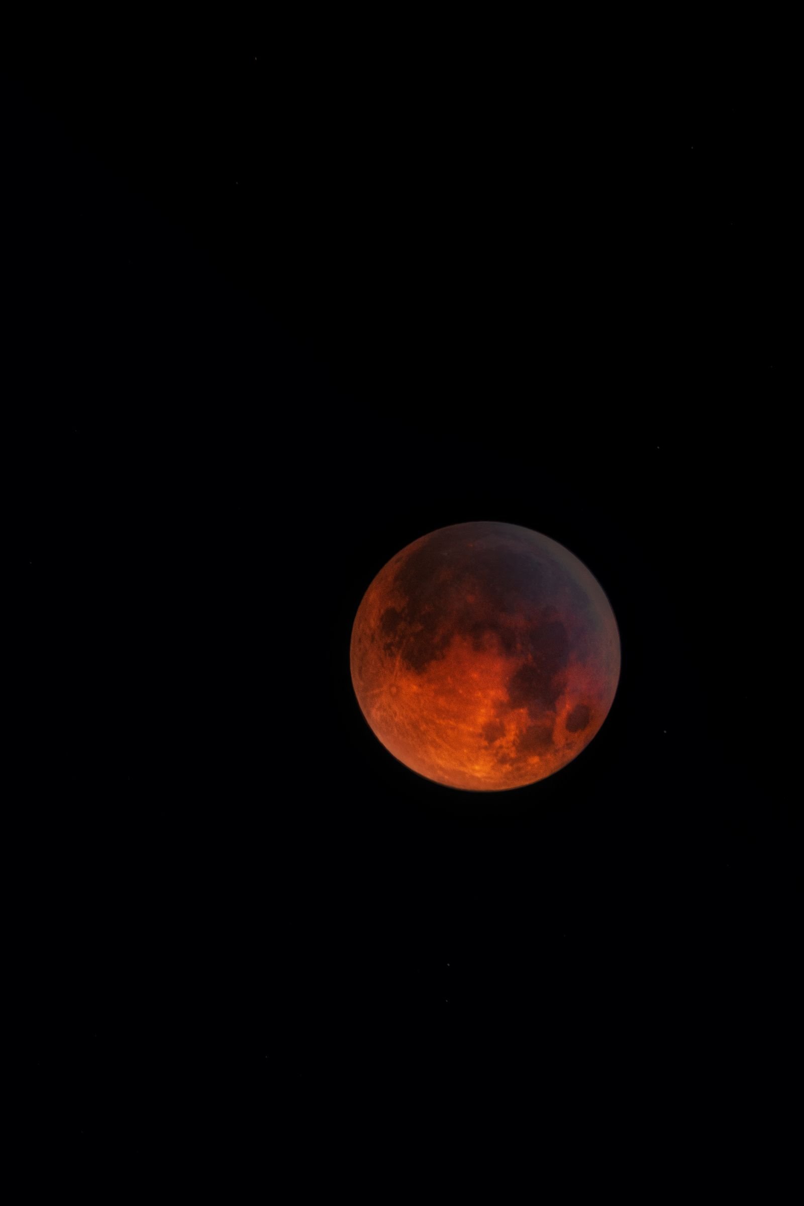 Blood moon during a total lunar eclipse in a starry sky