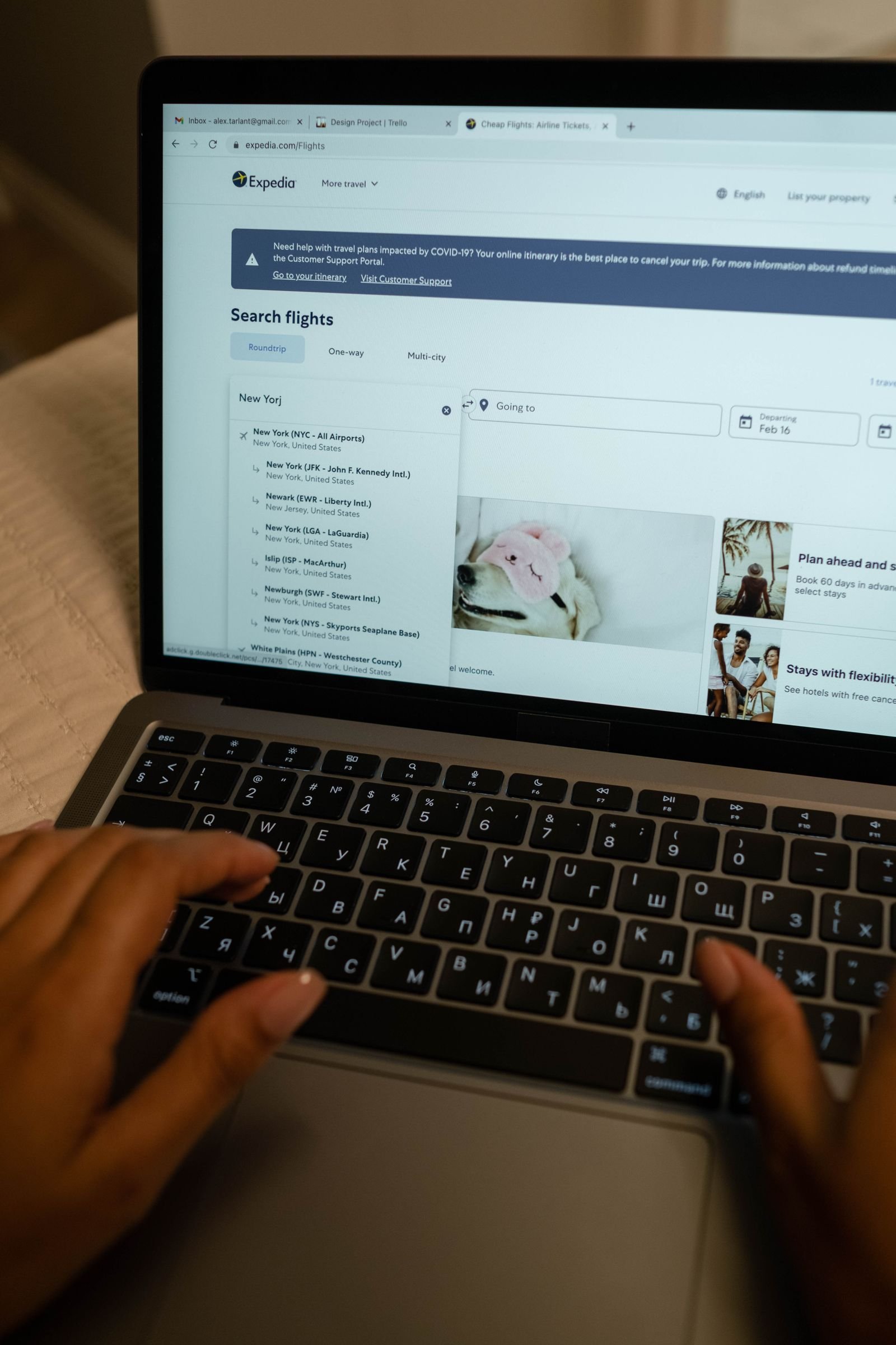 Traveller typing on a laptop to compare hotel and flight prices