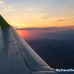 Airplane wing over a mountain landscape seen from a window seat