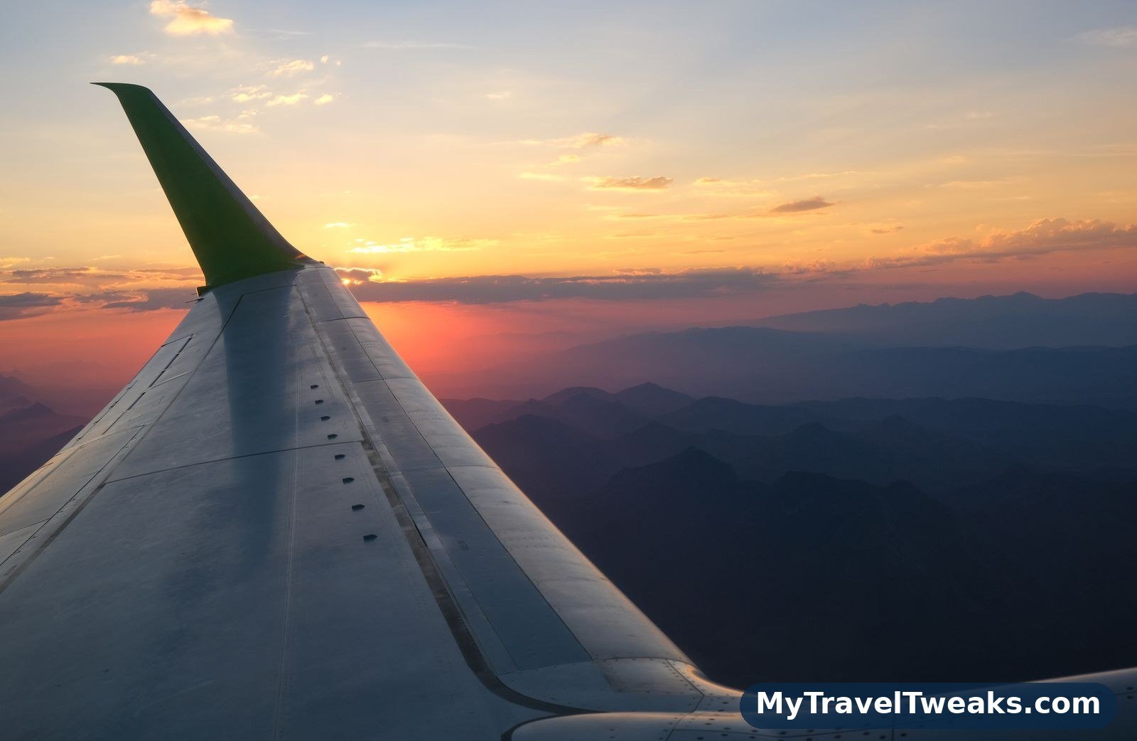 Airplane wing over a mountain landscape seen from a window seat