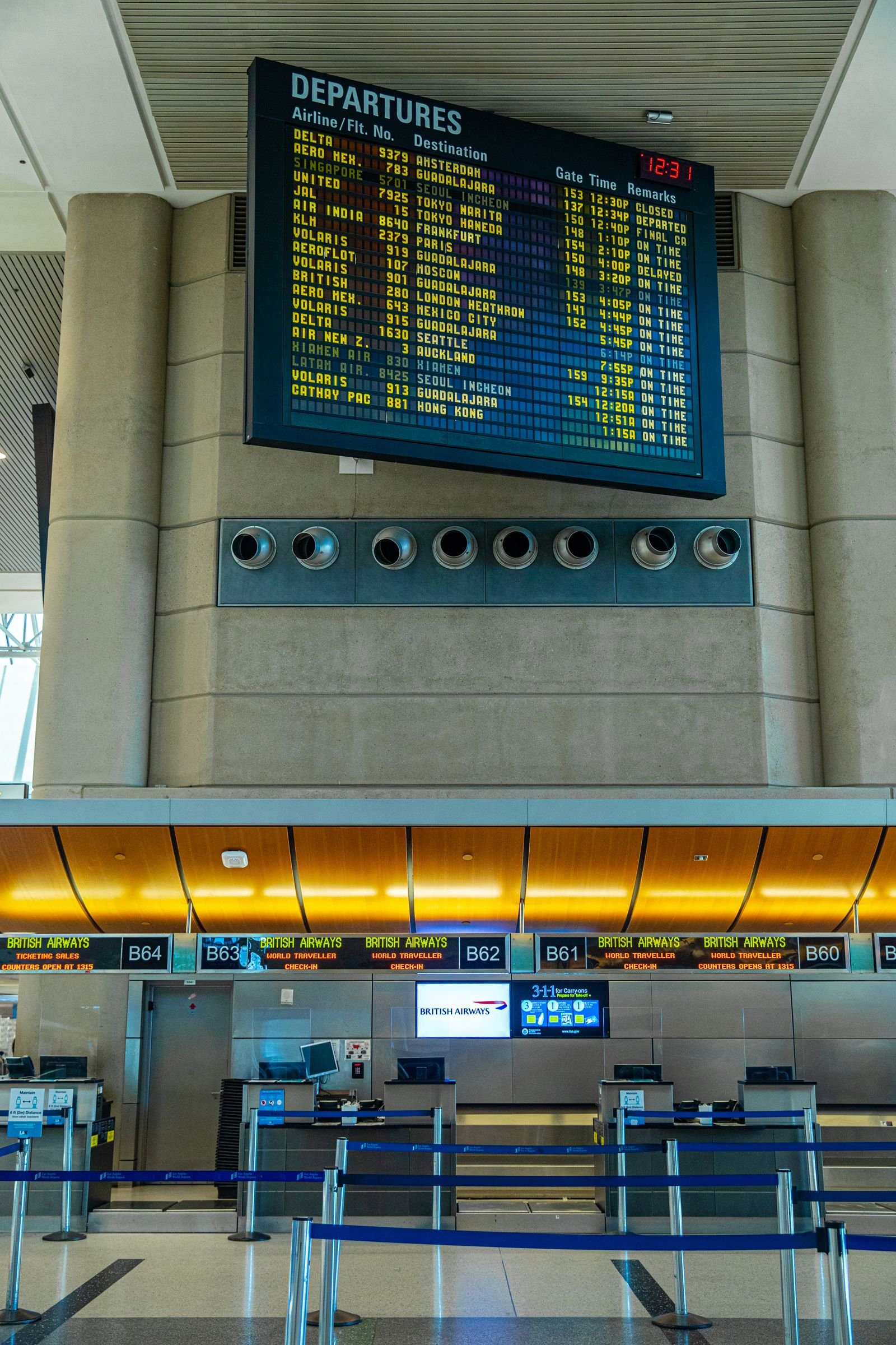 Departure board and check-in counters at a busy airport