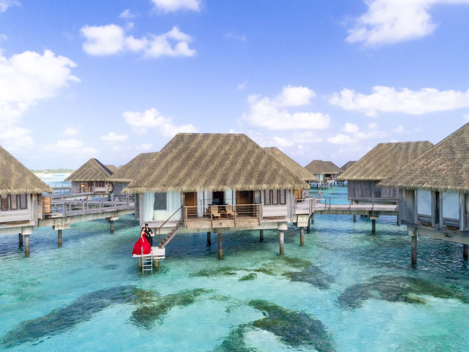 Thatched huts standing over clear turquoise water