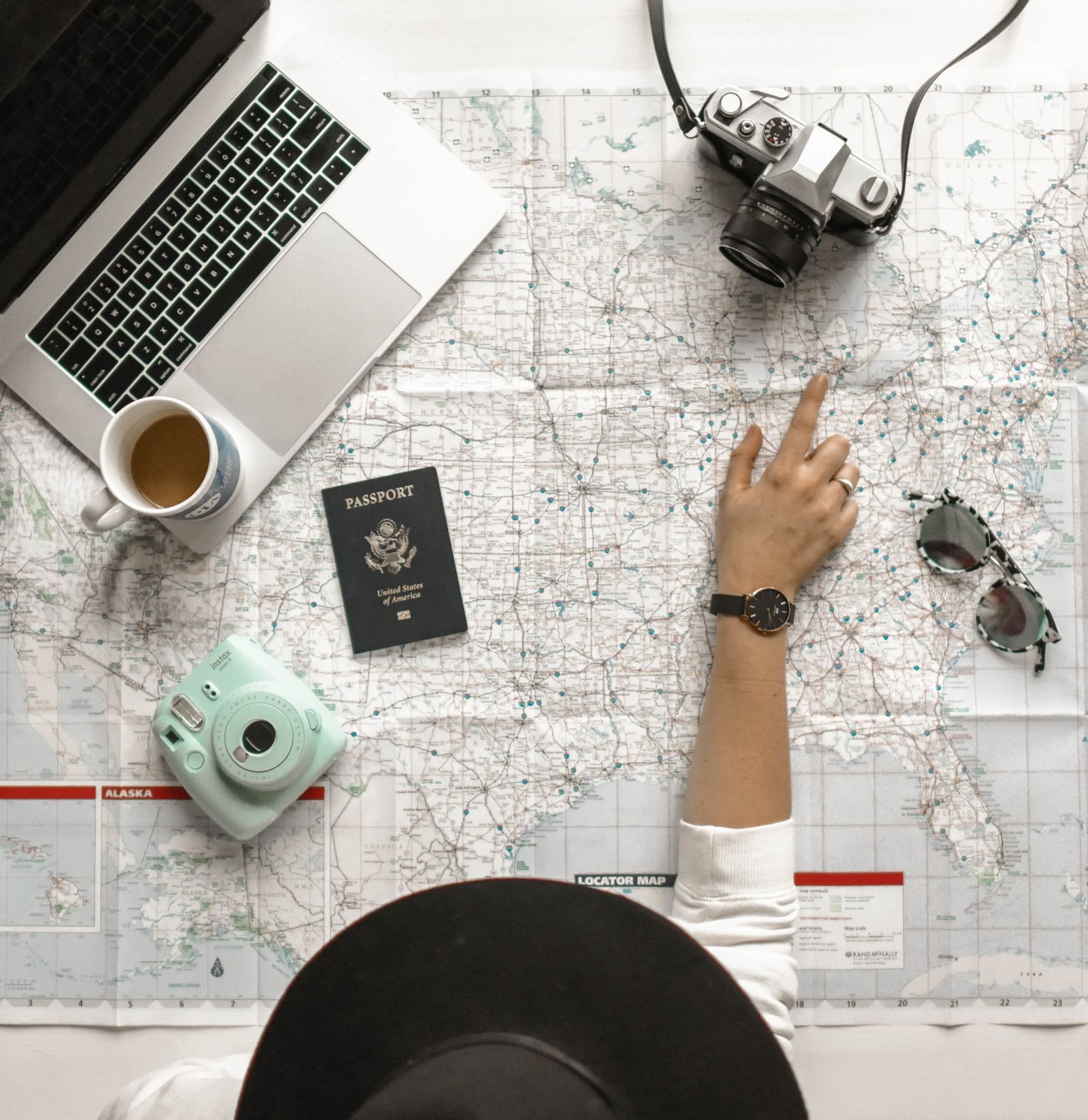 Planning a trip with a map, passport, camera and laptop